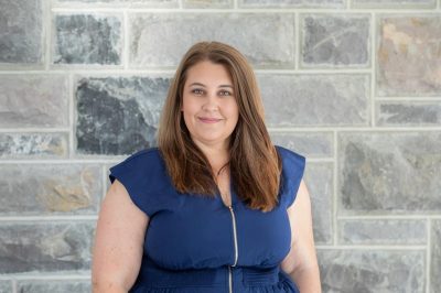 Photo of Ashley Bray standing in front of a Hokie Stone wall