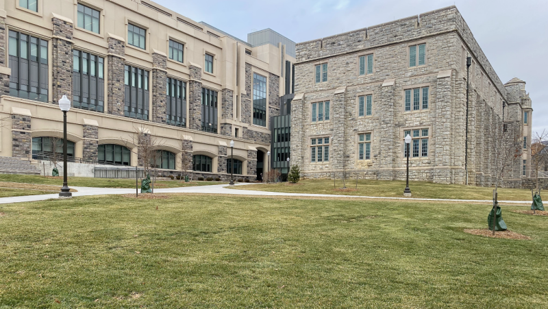 grassy quad in front of stone building with wide gradually inclined walkways